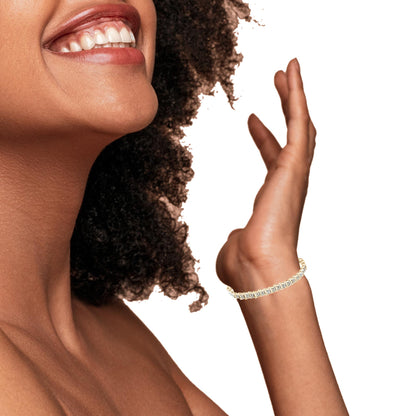 Yellow bracelet with round white gemstones in prong setting, shown on model's wrist, side angle.