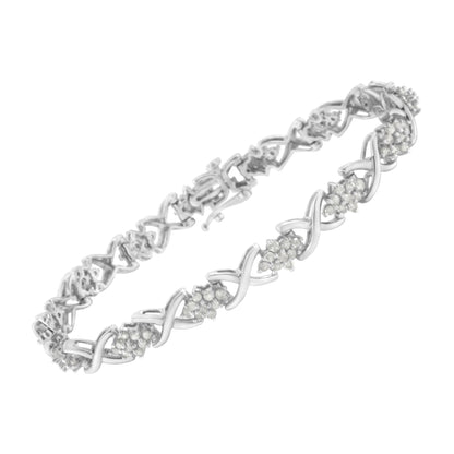 White metal bracelet with round white gemstones in prong settings arranged in clusters along an interwoven design, shown at an angle.