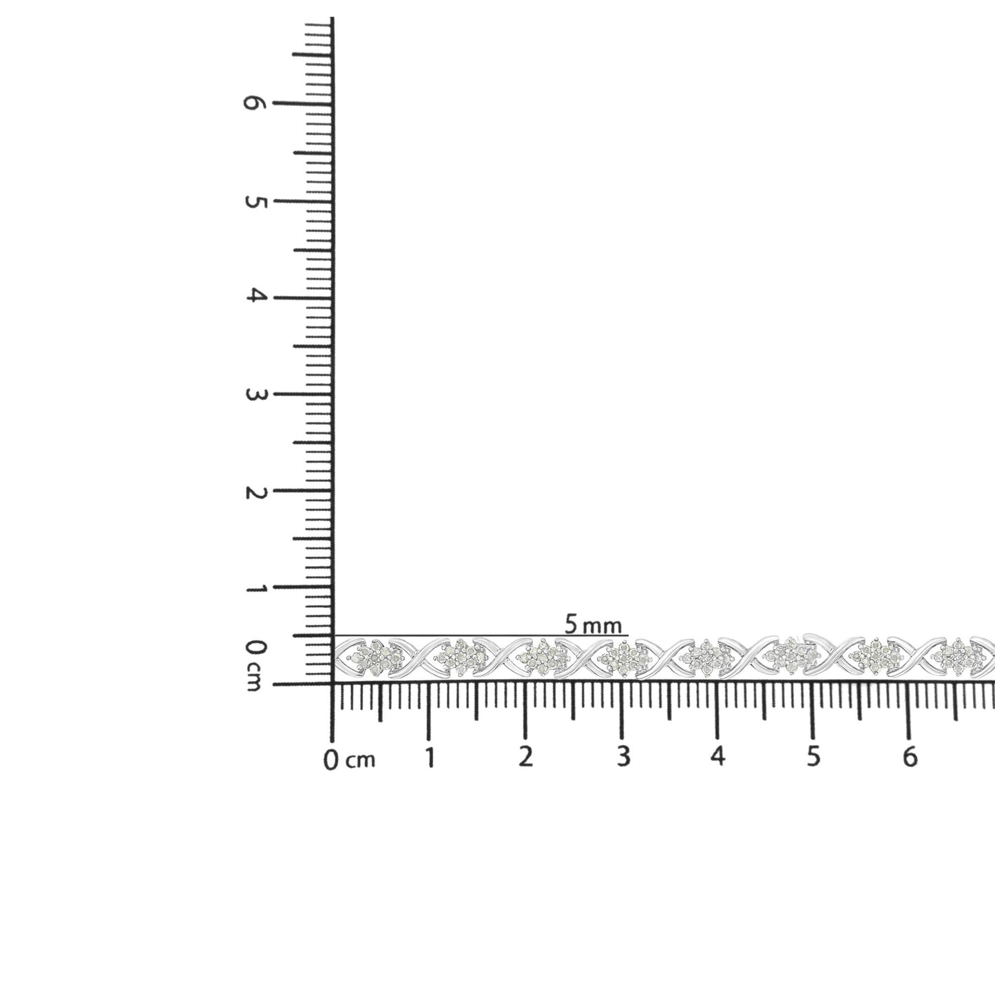 White metal bracelet with round white gemstones in prong settings, placed on ruler for size reference, front view.