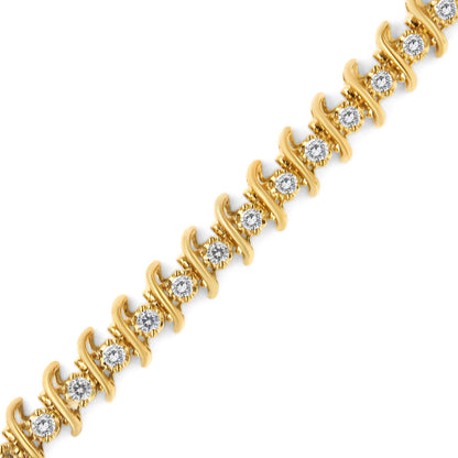 Diagonal close-up of a yellow metal bracelet with round white gemstones in prong settings.
