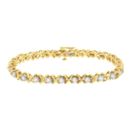 Front-facing shot of a yellow metal bracelet with an X-shaped link design and round white gemstones in prong settings.