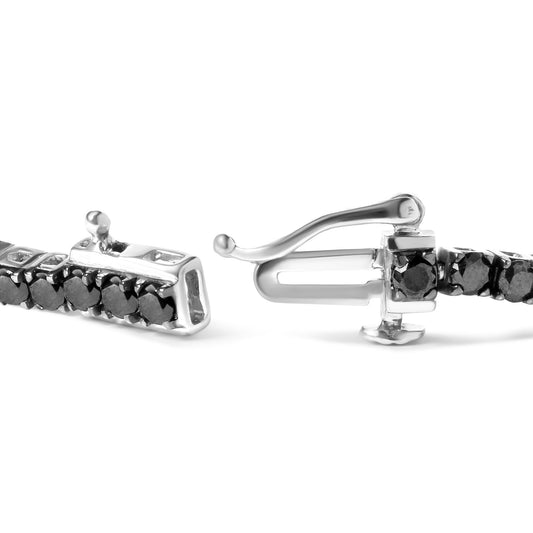 Close-up side angle of a white bracelet clasp set with round black gemstones in prong settings.