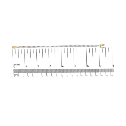 Yellow bracelet with round brownish gemstones in 4-prong setting, laid flat on a ruler for size reference, top-down view.