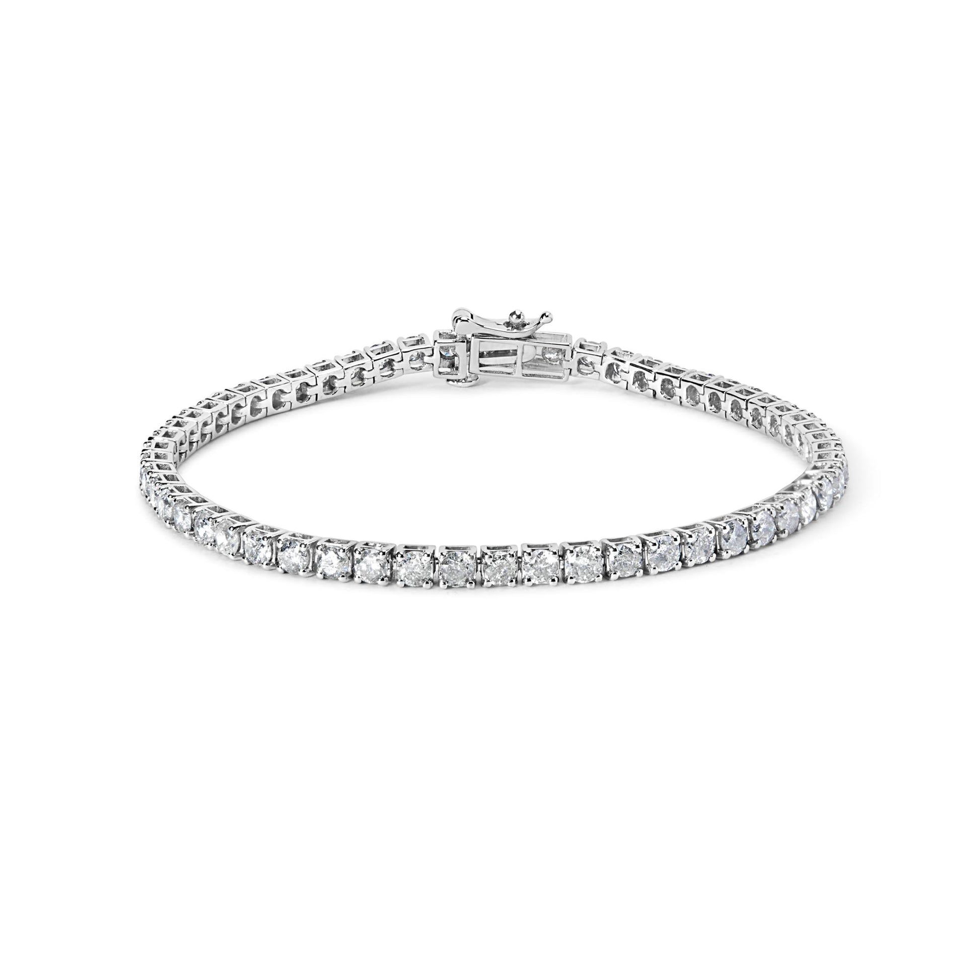 White metal bracelet with round white gemstones in 4-prong settings, shown flat with clasp visible, photographed from a slightly elevated angle.