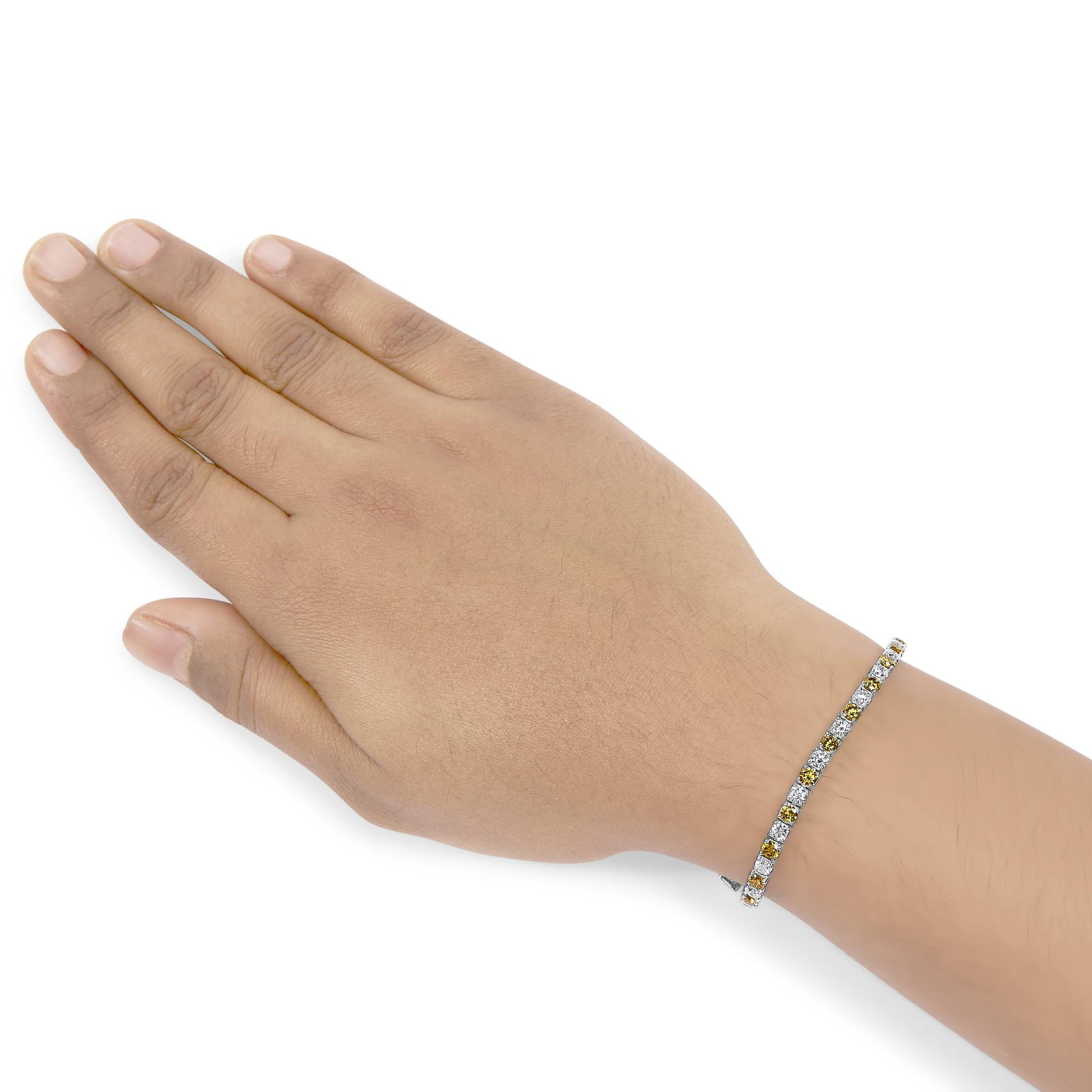 White metal bracelet with alternating round yellow and white gemstones in 4-prong settings, shown on a model's wrist, angled top-down.