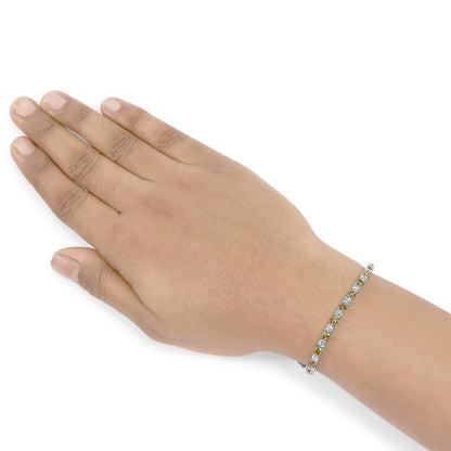 White metal bracelet with alternating round yellow and white gemstones in 4-prong settings, shown on a model's wrist, angled top-down.