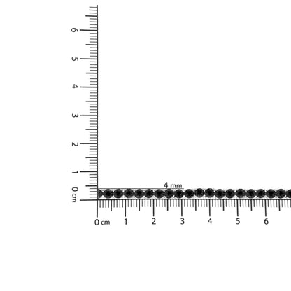 White metal bracelet with round black gemstones in a miracle setting, displayed horizontally on a ruler for size reference, top-down angle.