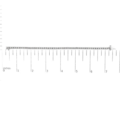 White metal bracelet with round white gemstones in miracle setting, laid flat on a ruler for size reference, shot from above.