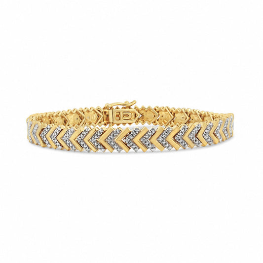 Close-up front angle of a yellow and white metal bracelet with chevron pattern adorned with round white gemstones in prong settings, shown on a white background.