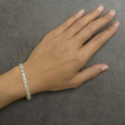 Bracelet with alternating yellow and white metal segments set with round white gemstones in prong settings, shown worn on a model's wrist, angled top view.