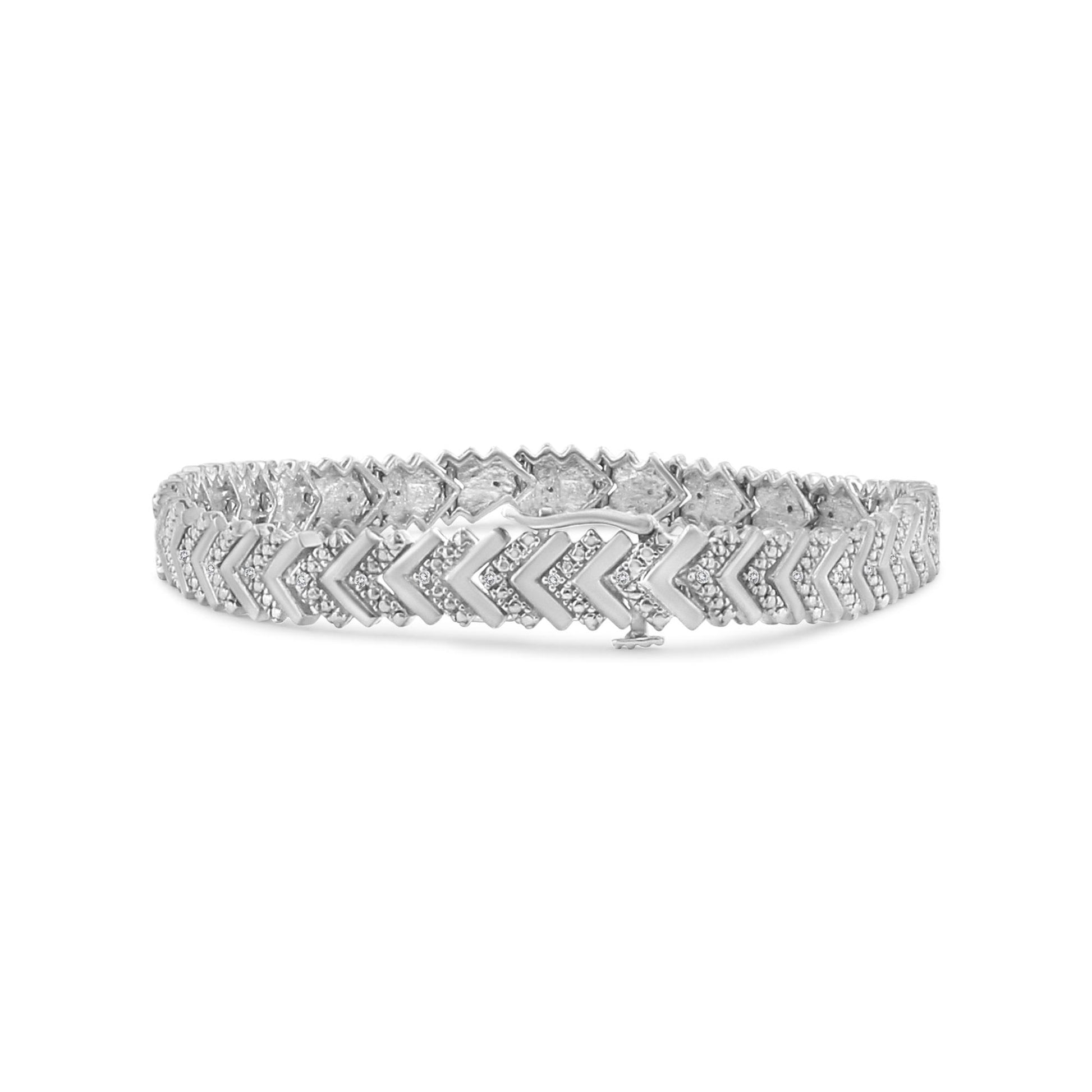 White metal bracelet with round white gemstones in prong settings forming a chevron pattern, shown from a front angle.