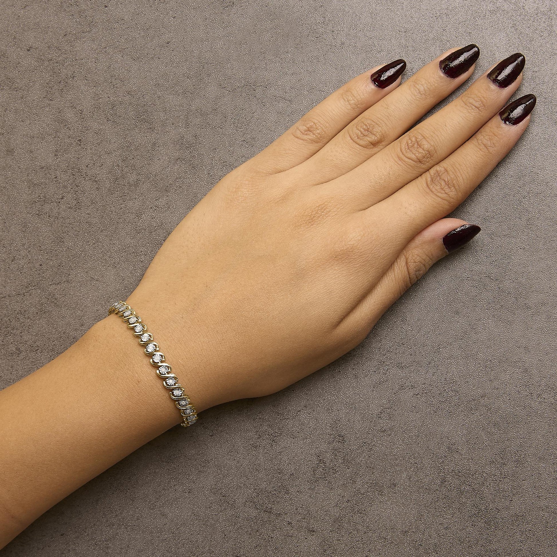 Bracelet with alternating yellow and white metal links, each set with a round white gemstone, shown on a model's wrist from top angle.