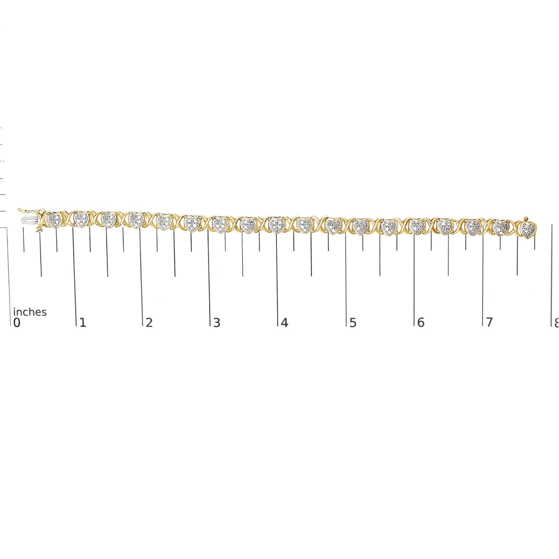 Bracelet with alternating yellow and white metal heart-shaped links with white gemstones in pave setting, displayed flat on a ruler for size reference, shot from above.