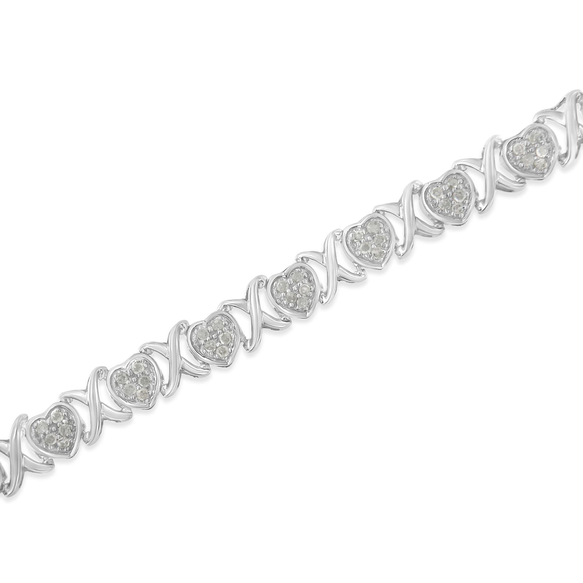 Diagonal close-up of a white metal bracelet featuring alternating heart-shaped settings with white gemstones and twisted links.