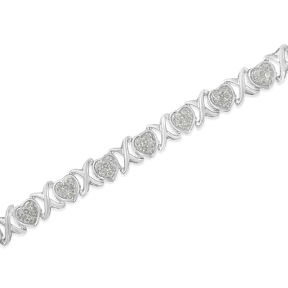 Diagonal close-up of a white metal bracelet featuring alternating heart-shaped settings with white gemstones and twisted links.