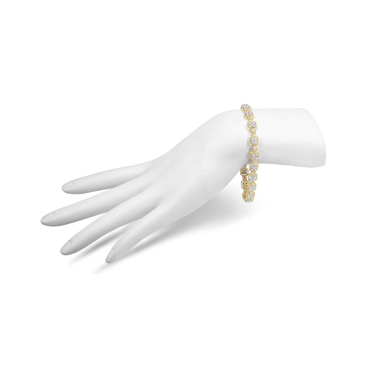 Yellow metal bracelet with round white gemstones in prong settings displayed on a white model hand, shown from a side angle.