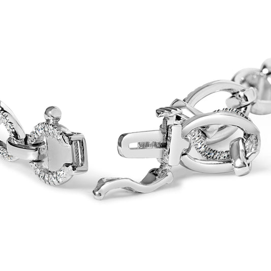 Close-up angle of a white metal bracelet with oval links partially set with round white gemstones, showing the open clasp mechanism.