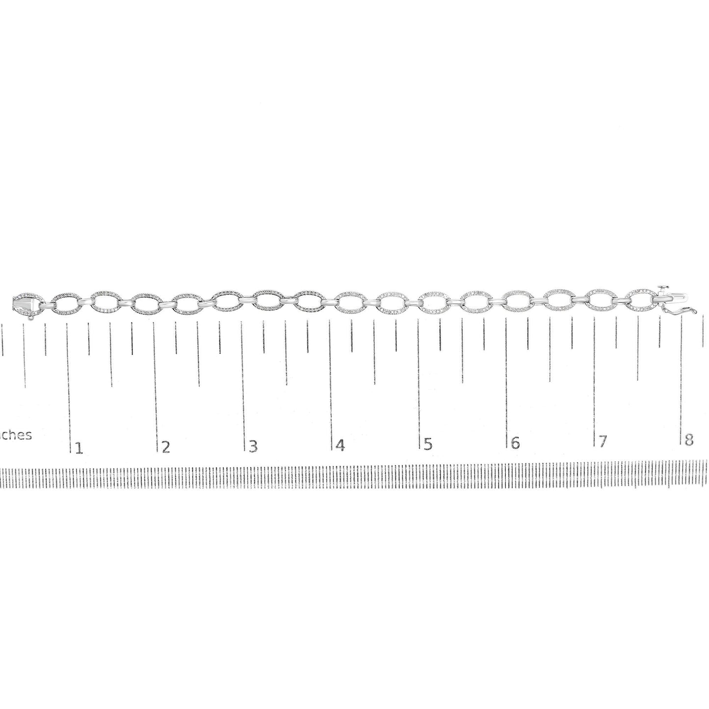 White metal bracelet with oval links set with round white gemstones in prong settings, laid flat on a ruler for size reference, top-down angle.