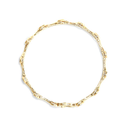 Top-down view of a yellow bracelet with linked segments, each set with round white gemstones in a miracle setting.
