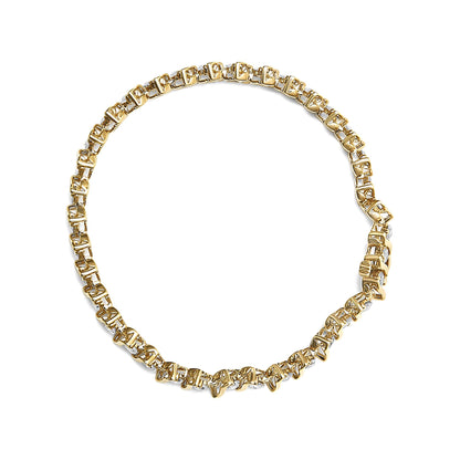 Top-down view of a yellow metal bracelet with round prong-set brownish gemstones linked in a circular design.