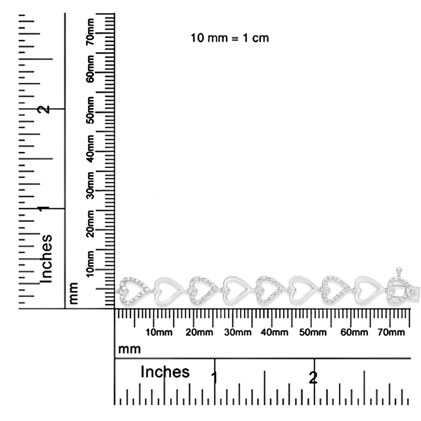 White metal bracelet with alternating solid and gemstone-studded heart links, positioned horizontally on a ruler for size reference, shot from above.