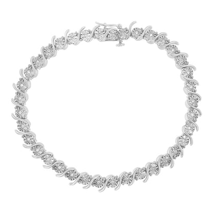 Top-down view of a white metal bracelet with round white gemstones set in an alternating swirl pattern.