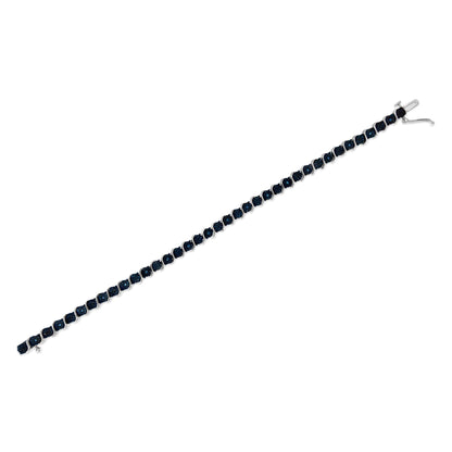 White bracelet shown in a diagonal angle with round blue gemstones in a miracle setting along its length.