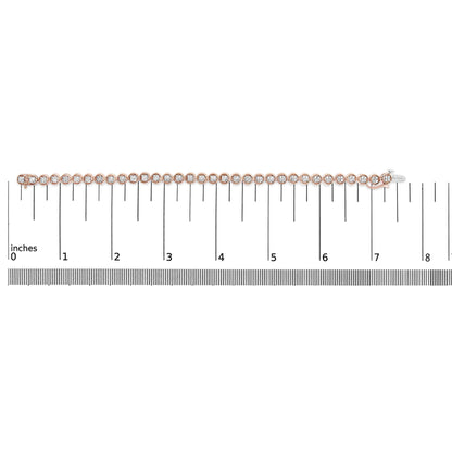 Top-down view of a rose-colored bracelet with round white gemstones in prong settings, placed on a ruler for size reference.