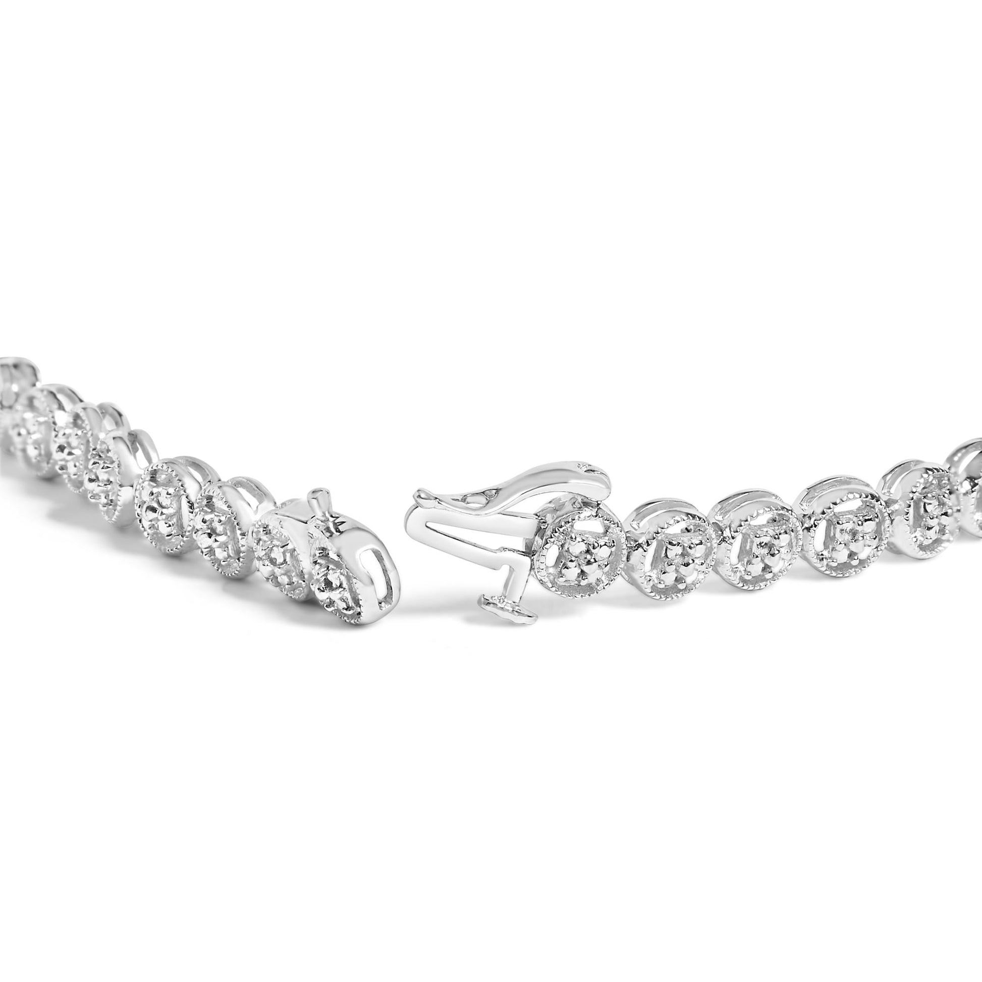 Close-up angled view of a white metal bracelet with round white gemstones in prong settings, showing the clasp open.