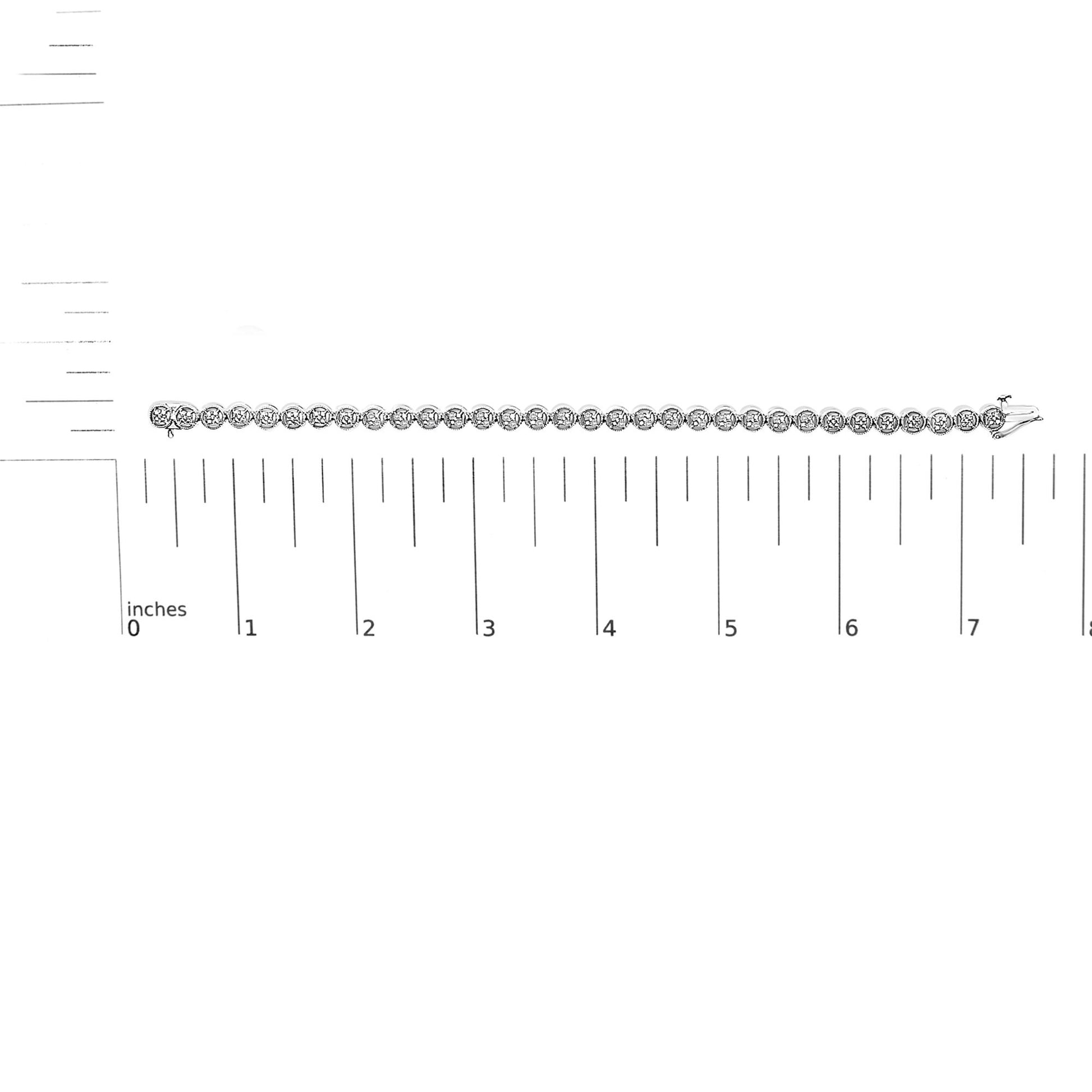 Top view of a white metal bracelet with round white gemstones in prong settings, laid flat on a ruler for size reference.