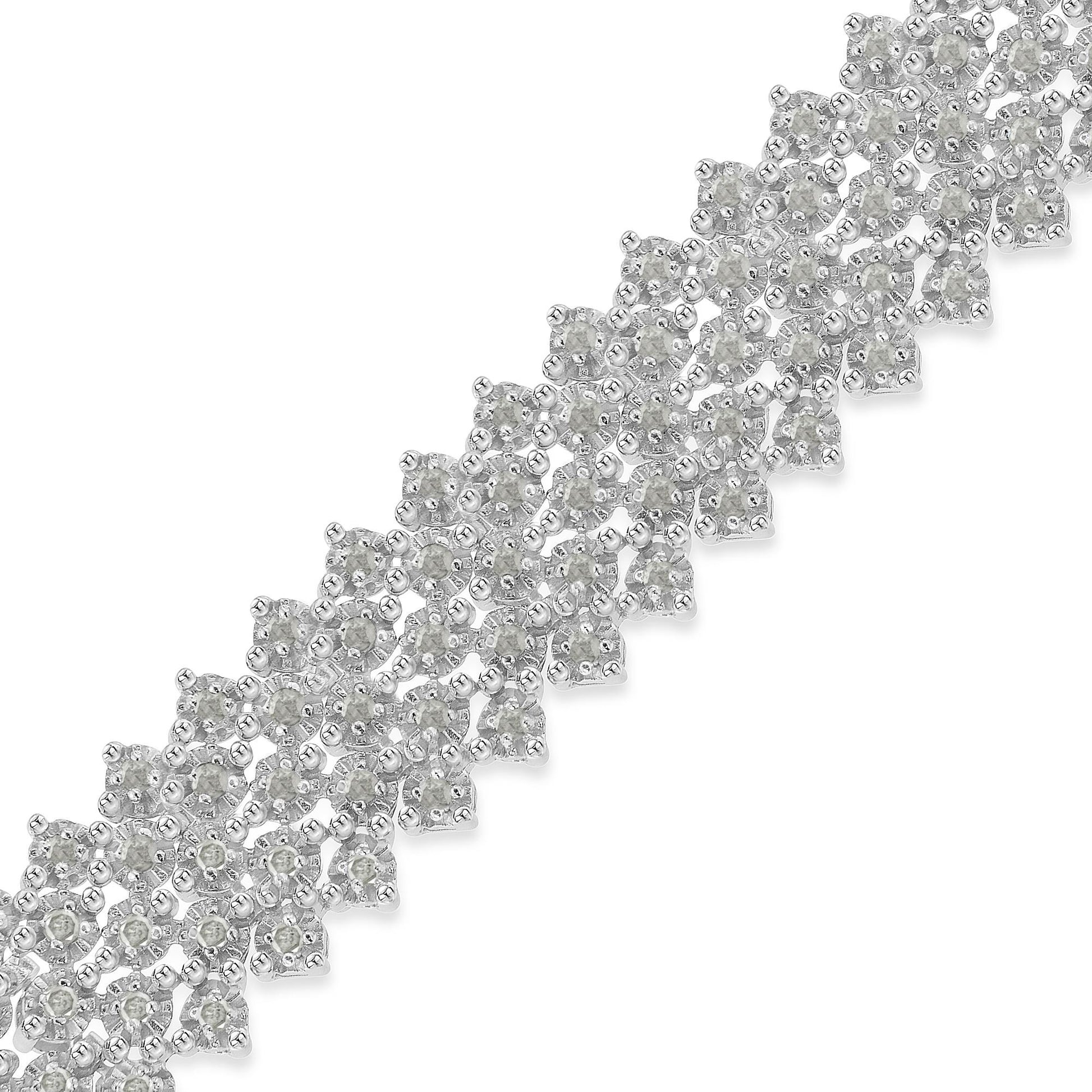 Close-up of a white metal bracelet with round white gemstones in prong settings, shot at an angle.