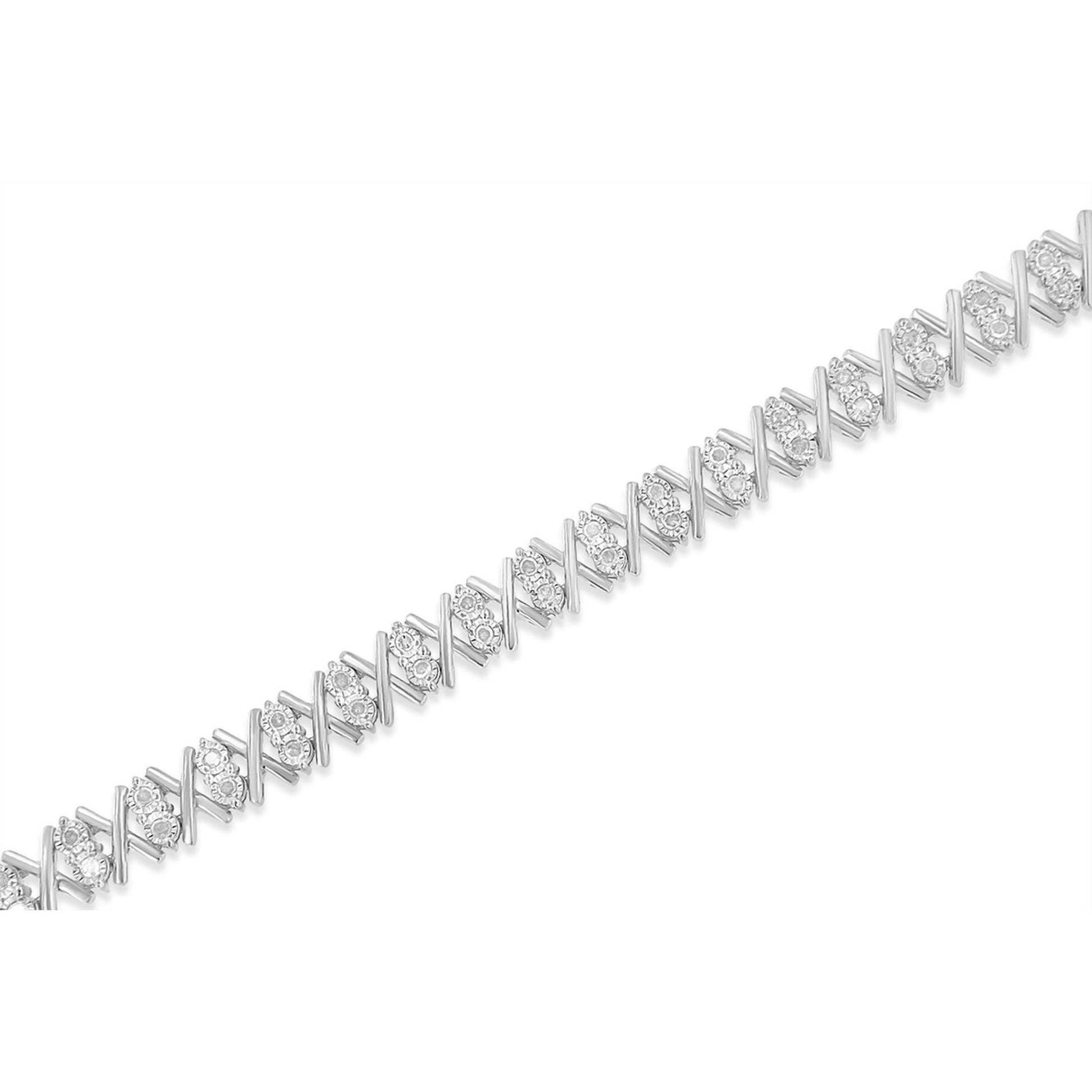 Close-up diagonal shot of a white metal bracelet with alternating X-shaped links and clusters of round white gemstones in miracle settings.