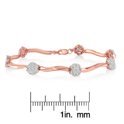 Rose metal bracelet with clusters of white round gemstones in prong settings, laid flat and shown from a side angle on a ruler for size reference.