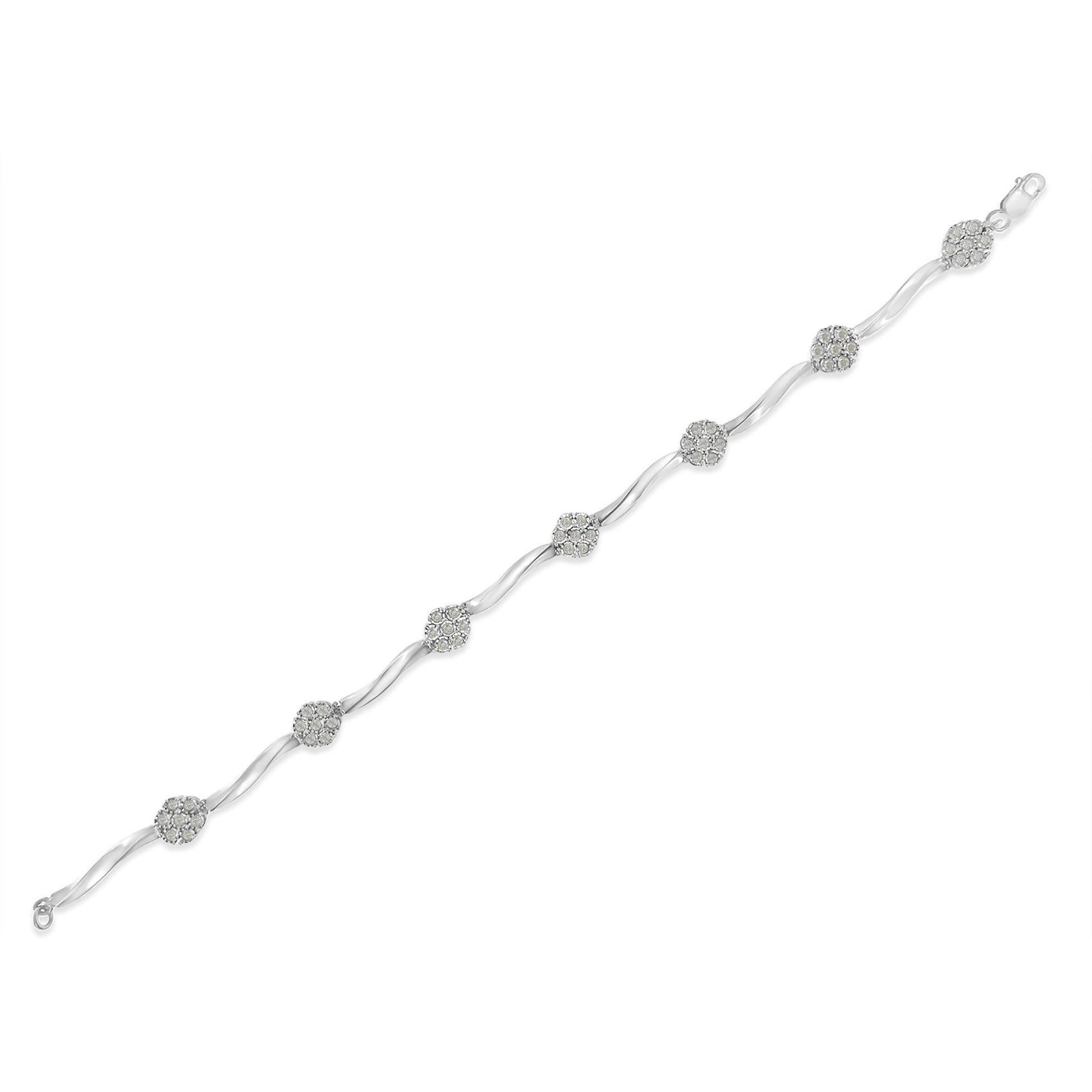 White metal bracelet with alternating curved links and round clusters of small white gemstones, shown laid flat in a top-down angled view.