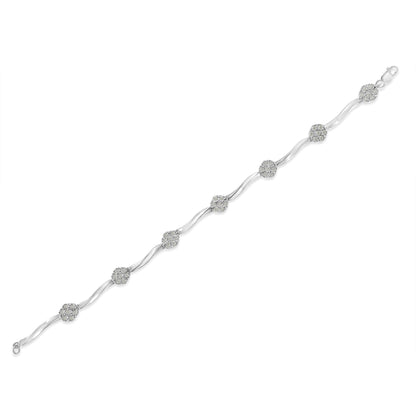 White metal bracelet with alternating curved links and round clusters of small white gemstones, shown laid flat in a top-down angled view.