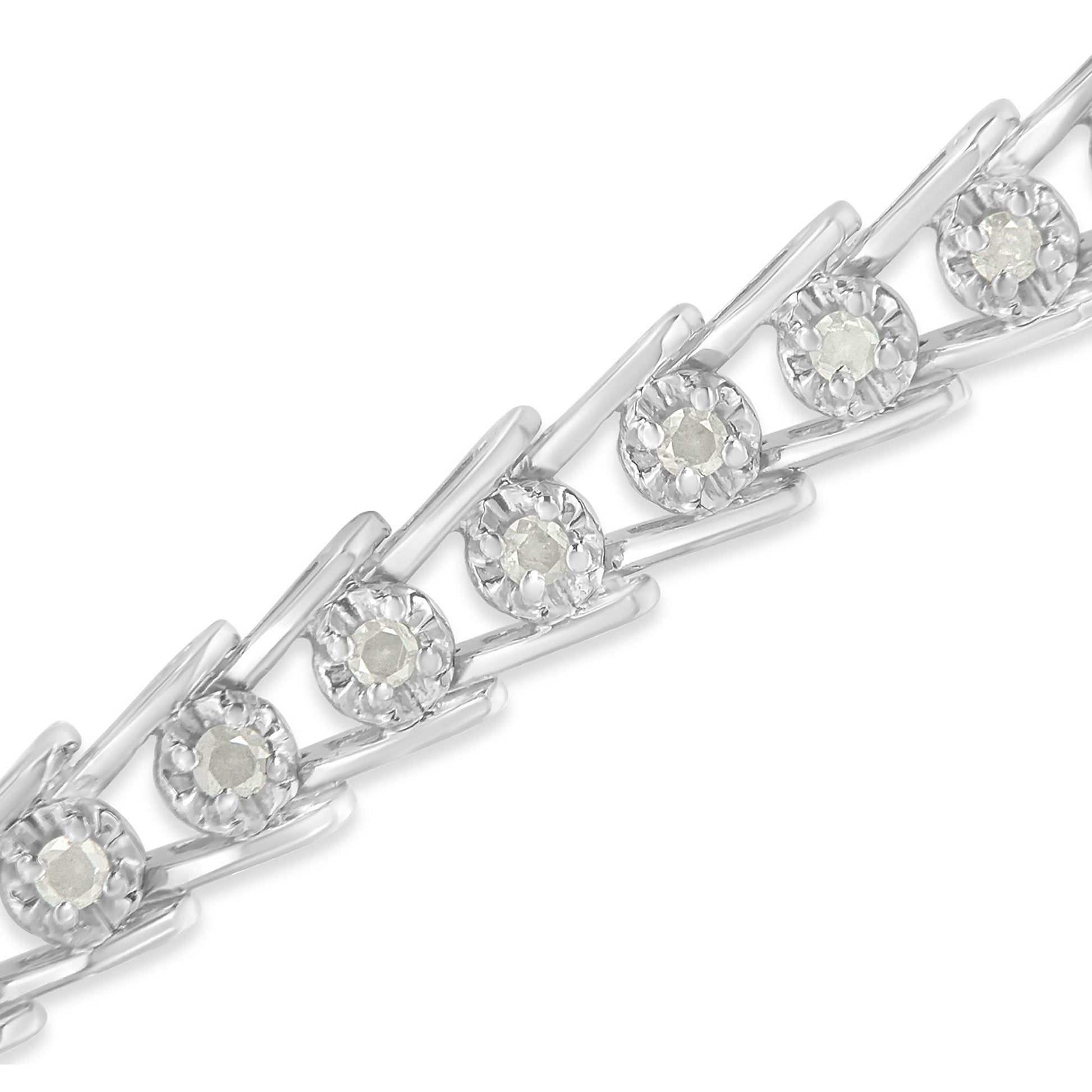 Close-up diagonal view of a white metal bracelet with round white gemstones in prong settings.