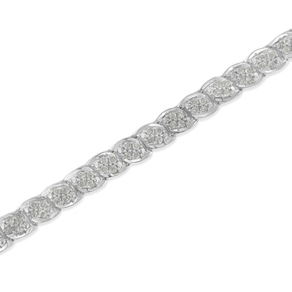 Close-up, angled top view of a white metal bracelet featuring multiple sections each set with clusters of round white gemstones in prong settings.