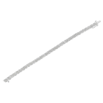 White metal bracelet with round white gemstones in prong settings, shown in a diagonal flat lay angle.