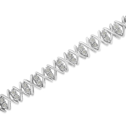 White metal bracelet with alternating zigzag links and clusters of round white gemstones, shown in a diagonal close-up angle.