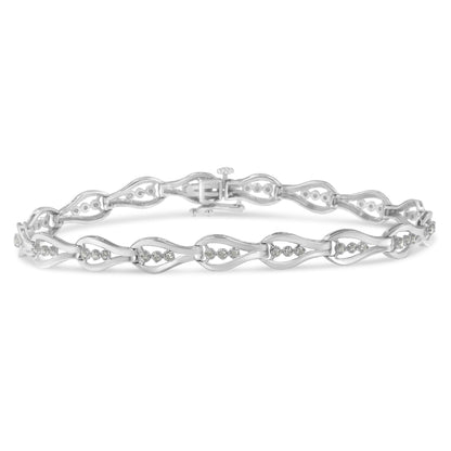 White metal bracelet with linked wave-shaped sections each set with round white gemstones, shown in a flat horizontal position from a front angle.