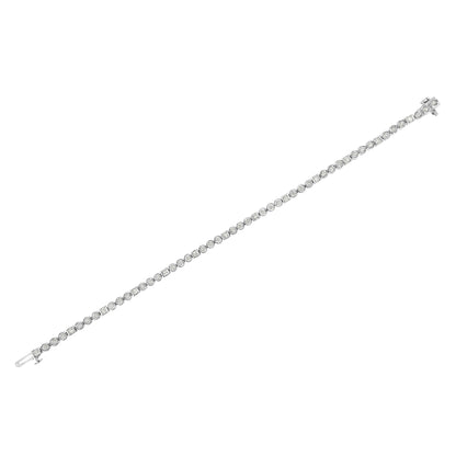 White metal bracelet with alternating round and baguette white gemstones, shown in a diagonal flat lay angle.