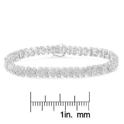 White metal bracelet with round white gemstones in miracle setting, shown in a front angle on a scale for size reference.