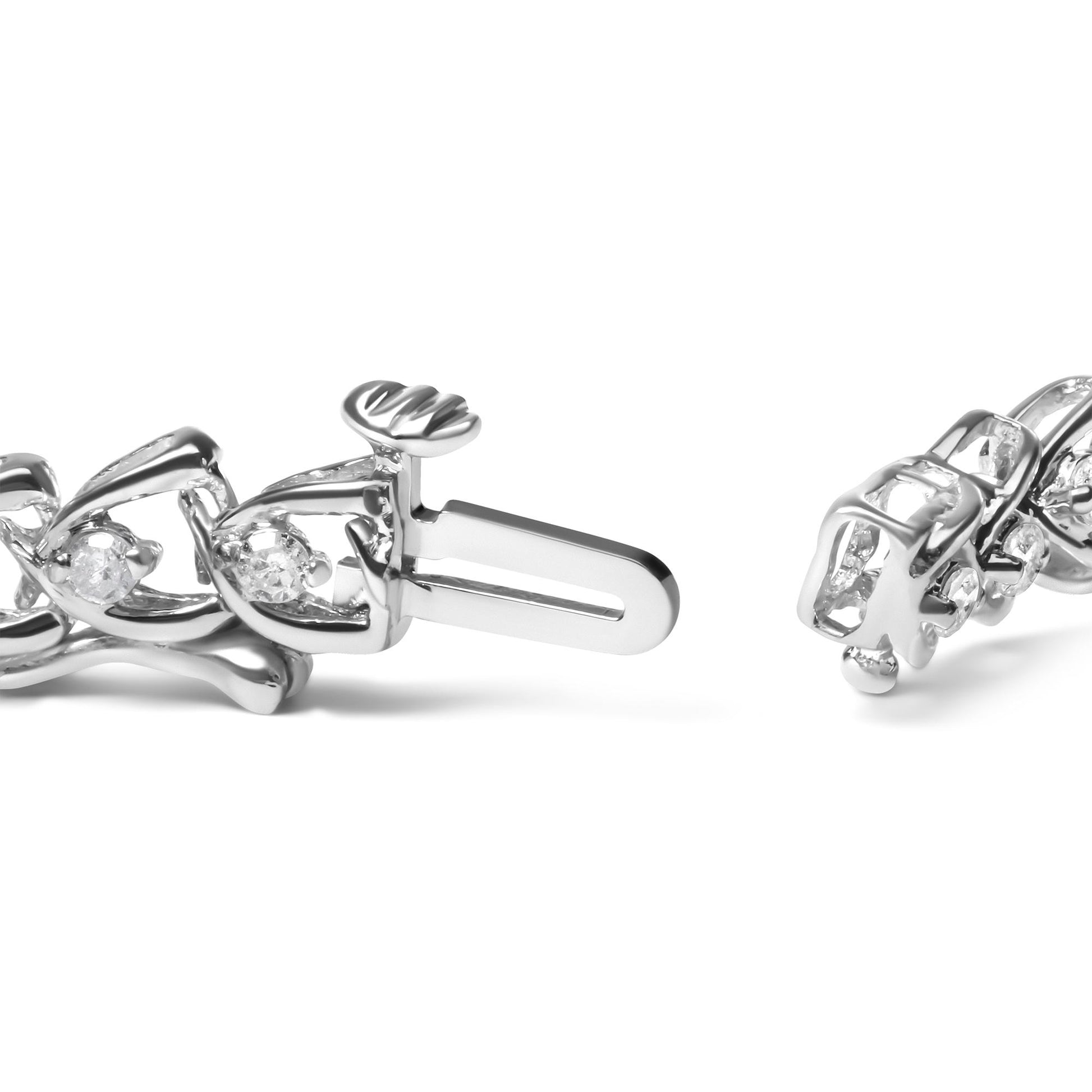 Close-up angled view of a white metal bracelet with round white gemstones in prong settings, showing the clasp mechanism.