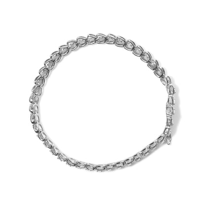 Top-down view of a white metal bracelet featuring round prong-set white gemstones in a continuous linked design.