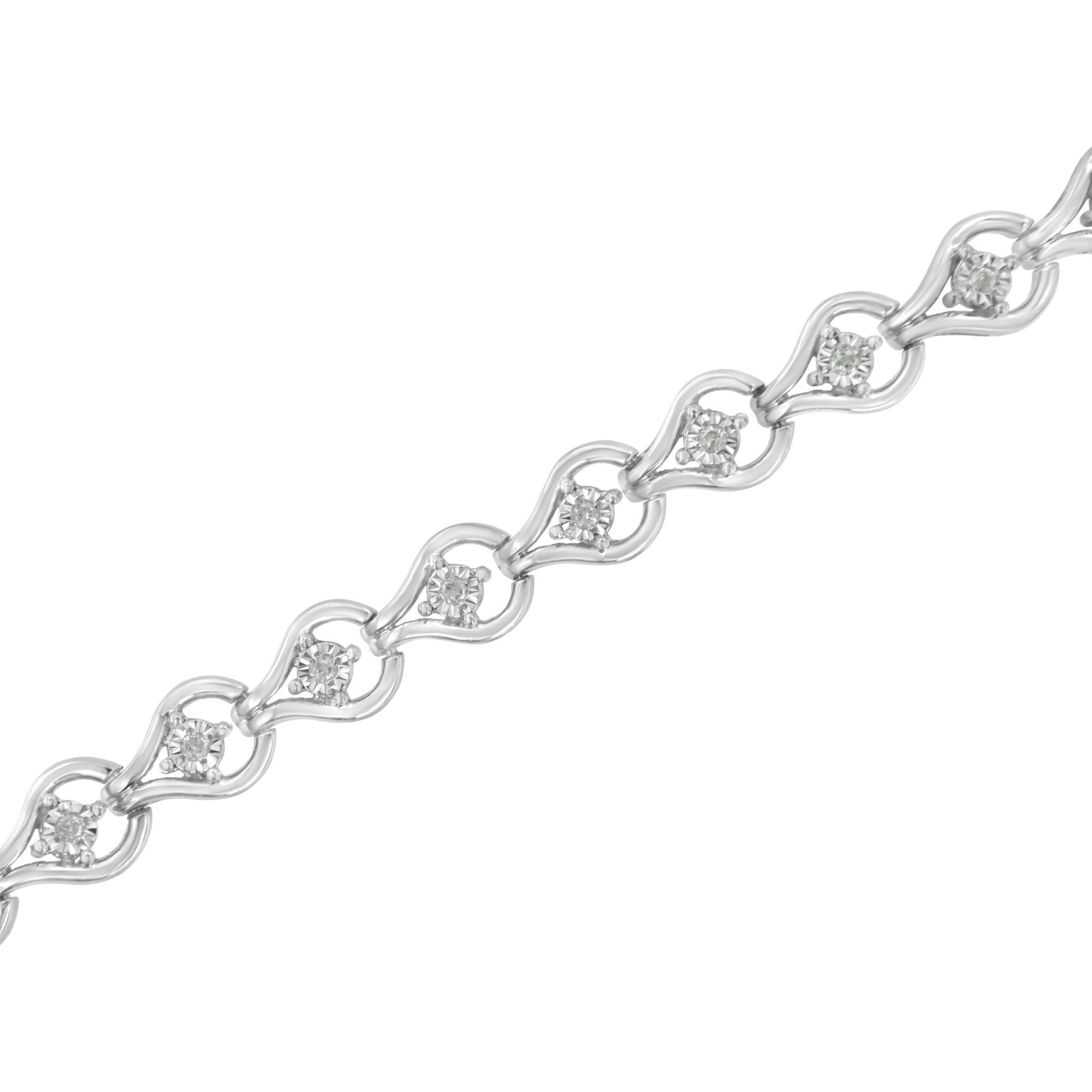 Diagonal close-up of a white metal bracelet with round white gemstones set in a miracle setting within delicate linked shapes.