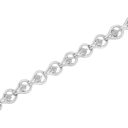 Diagonal close-up of a white metal bracelet with round white gemstones set in a miracle setting within delicate linked shapes.