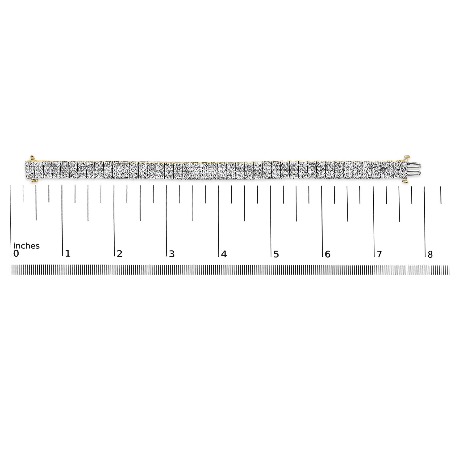 Yellow metal bracelet with rows of white round gemstones in shared prong setting, displayed flat on a ruler scale, shot from above.