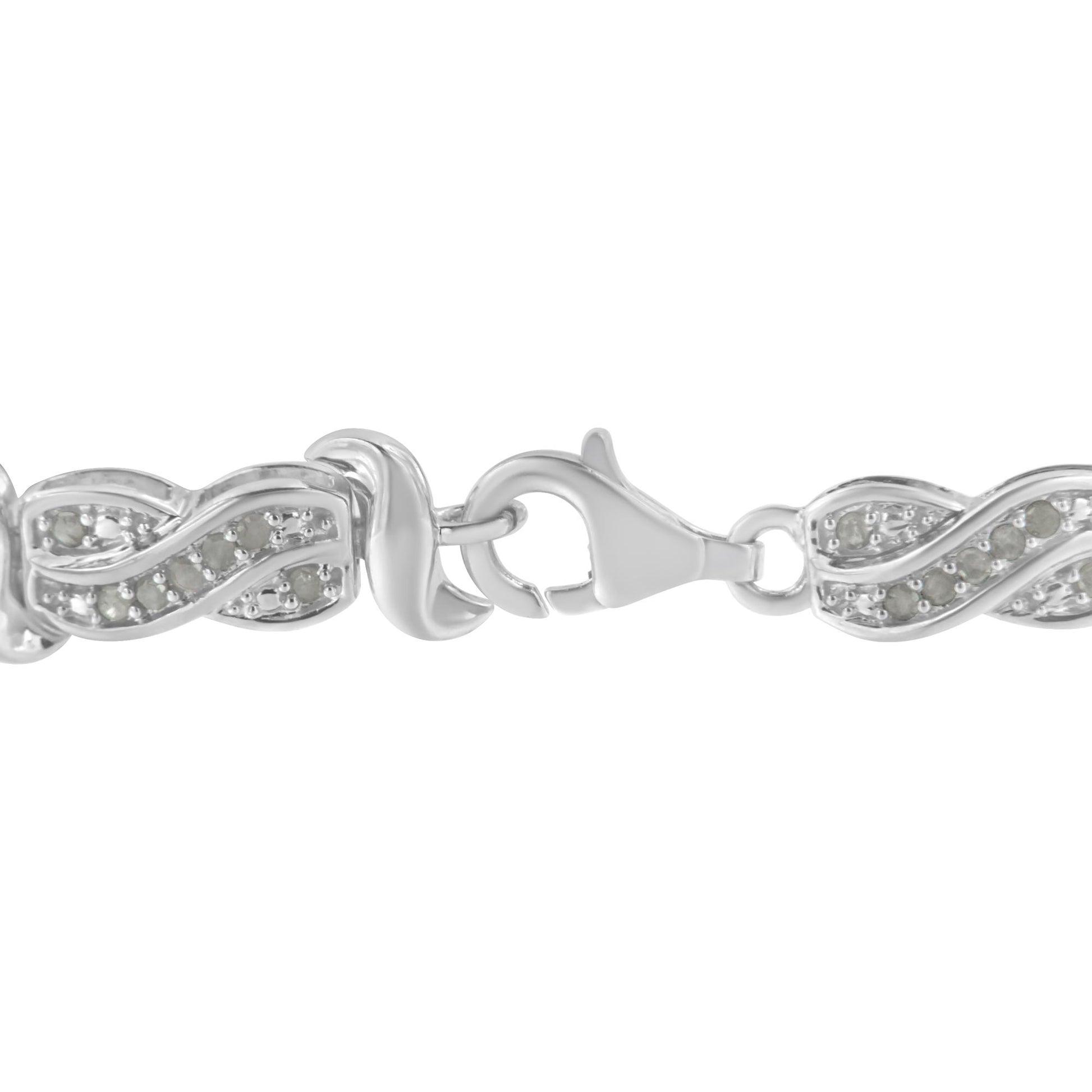 Close-up front angle of a white metal bracelet with a lobster clasp and linked segments featuring a waved design set with round white gemstones in pave setting.