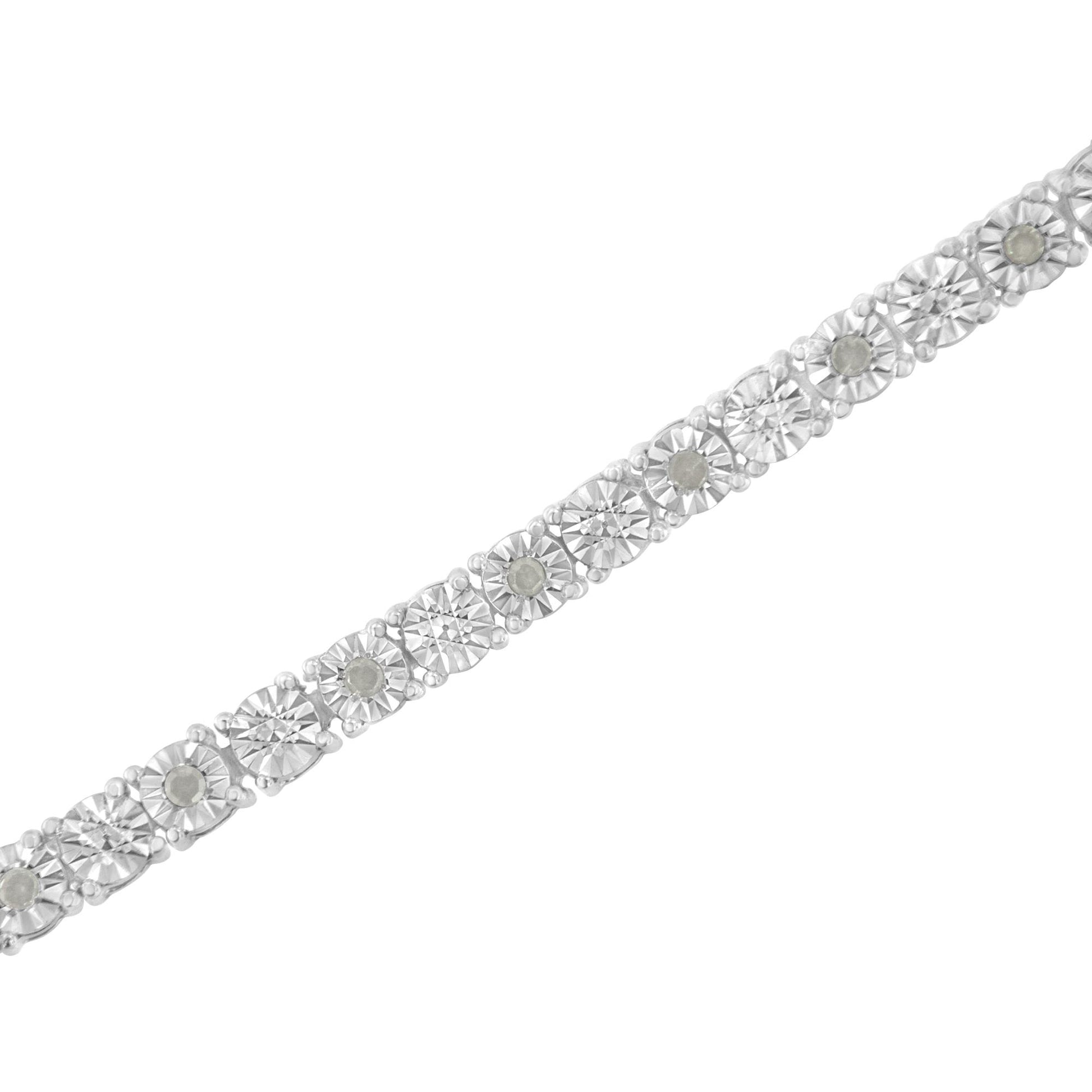 Diagonal close-up of a white metal bracelet set with round prong-set white gemstones.