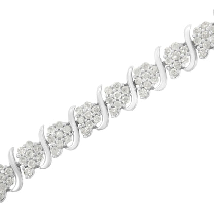 Close-up angled shot of a white metal bracelet featuring clusters of round white gemstones in prong settings alternating with smooth curved metal links.